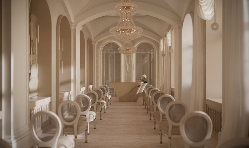 An elegant hall lined with white chairs beneath a crystal chandelier