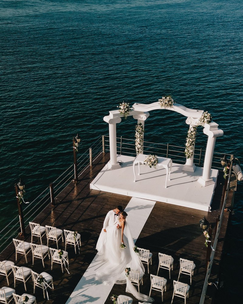 An aerial view of a wedding ceremony set up on a platform over a lake