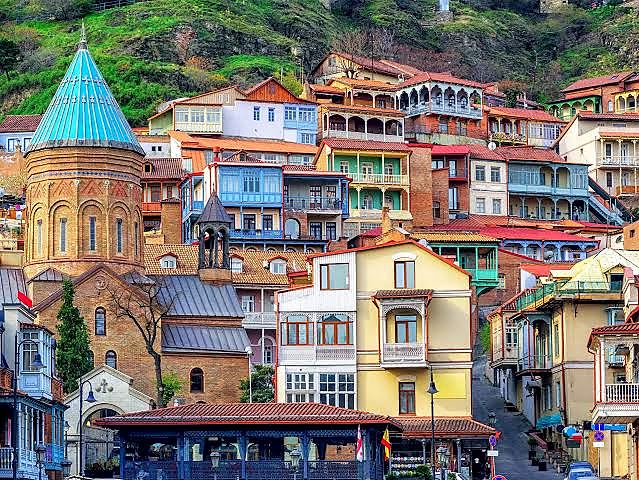 Tbilisi Old Town skyline along the Mtkvari River at sunset
